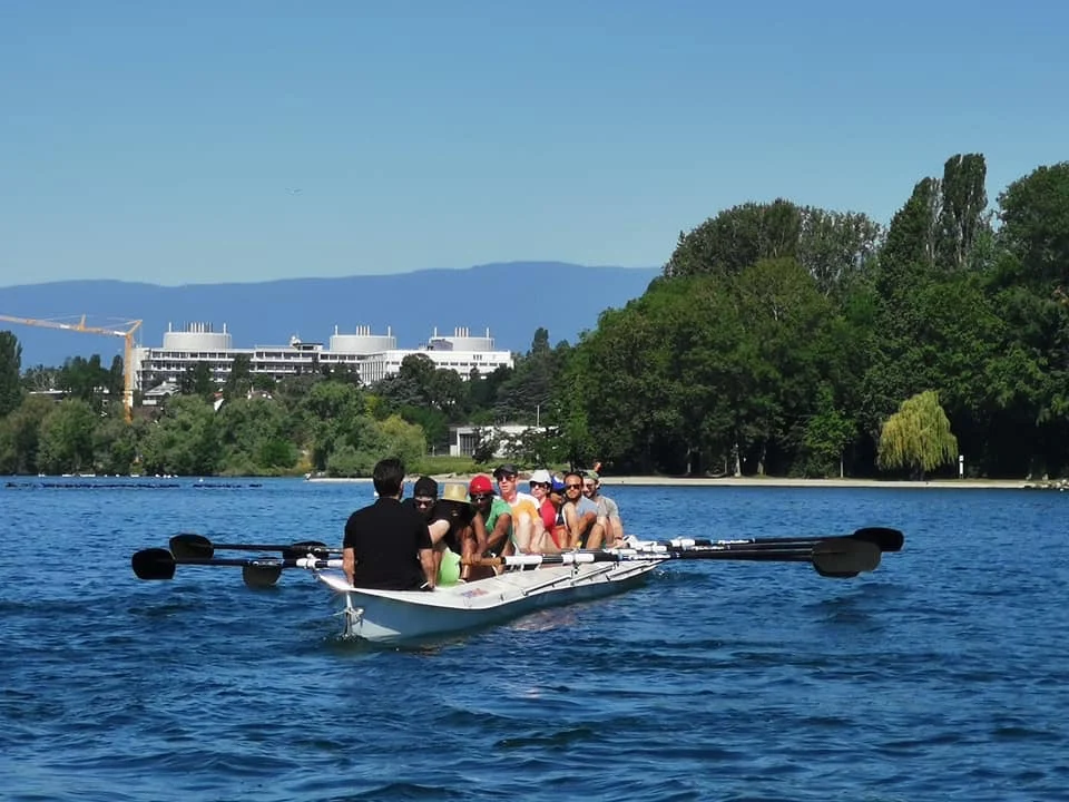 Illustrative photograph: a crew of eight rowers moves across a body of water